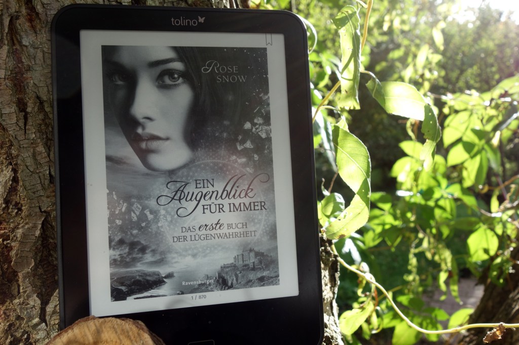 Das Cover "Ein Augenblick für immer - Das erste Buch der Lügenwahrheit" von Rose Snow fotografiert an einem Baumstamm