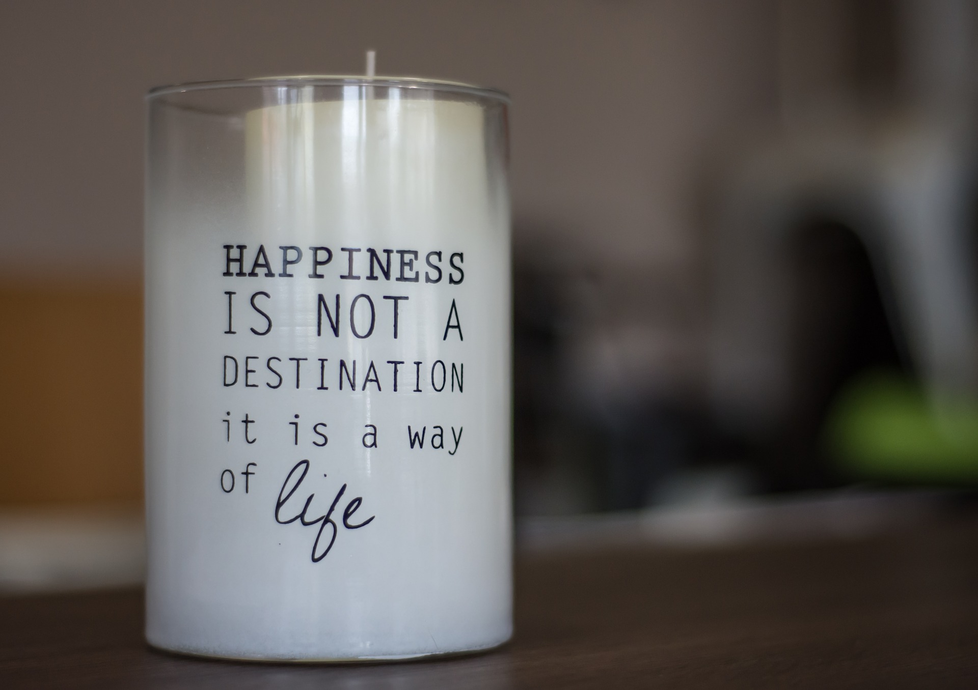 Kerze mit der Aufschrift "Happyness is not a destination it is a way of life" (Bild von Christo Anestev auf Pixabay)