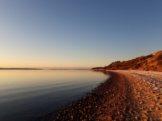 Limfjord im Sonnenuntergang, links das Wasser, rechts der Strand