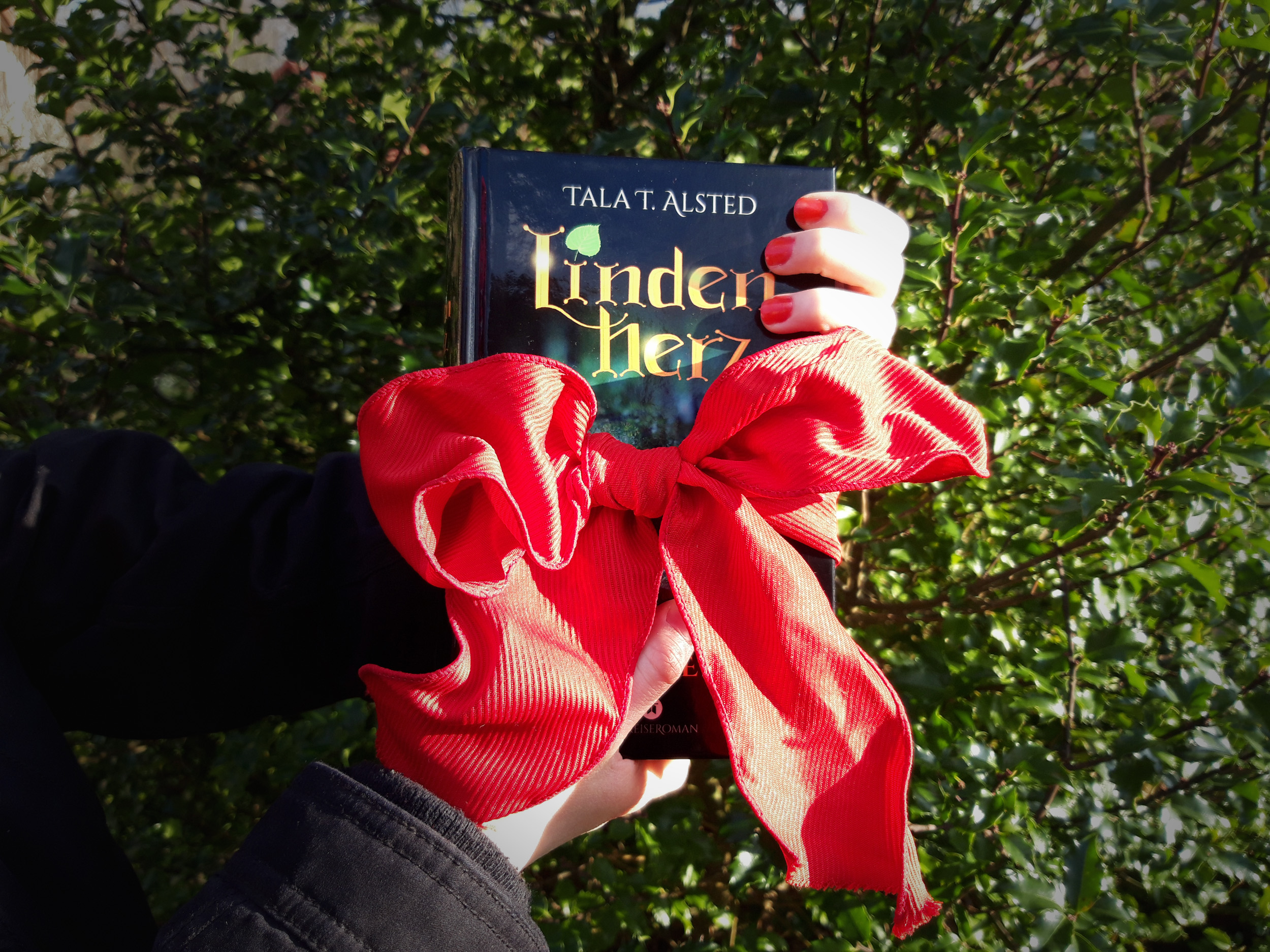 Hardcover "Lindenherz - 824 Jahre durch die Zeit" mit einer roten Schleife