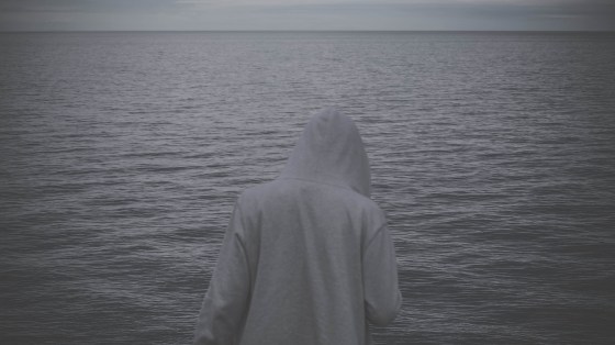 Mann in weißem Hoodie vorm Meer mit dem Rücken zur Kamera - Image by StockSnap from Pixabay