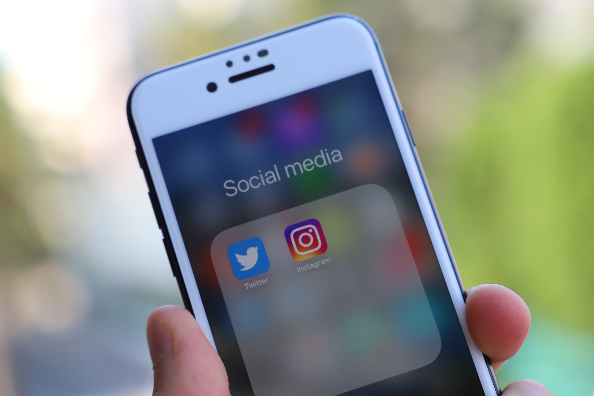 Handy in der Hand, auf dem Display der Text "Social Media" mit den Apps Twitter und Instagram -Image by MrJayW from Pixabay