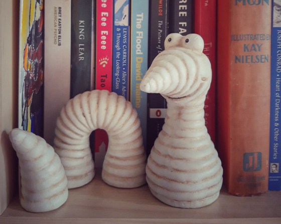 Bücherwurm aus Keramik im Bücherregal